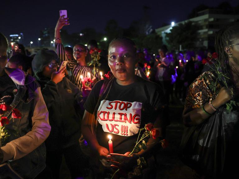 Aktivistinnen strecken Kerzen und rote Rosen in die Höhe, eine Mahnwache zum Gedenken an junge Frauen, die bei geschlechtsspezifischer Gewalt ums Leben gekommen sind. Nairobi, 14. Februar 2024.