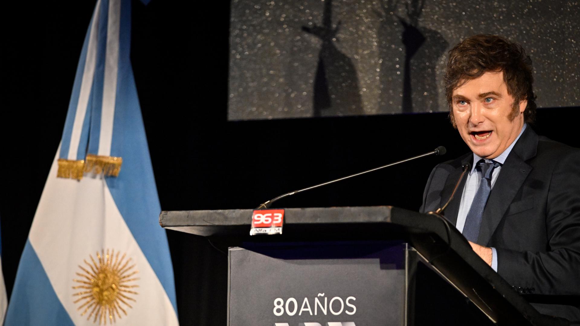 Javier Milei, Präsident von Argentinien, hält eine Rede; links steht die argentinische Flagge.