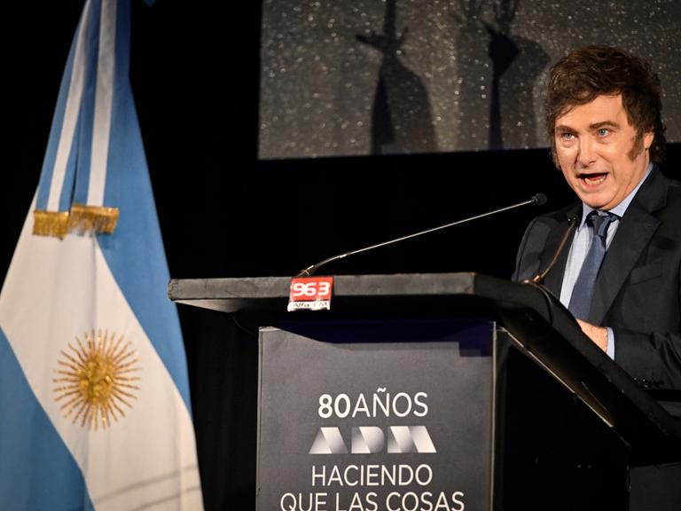 Javier Milei, Präsident von Argentinien, hält eine Rede; links steht die argentinische Flagge.
