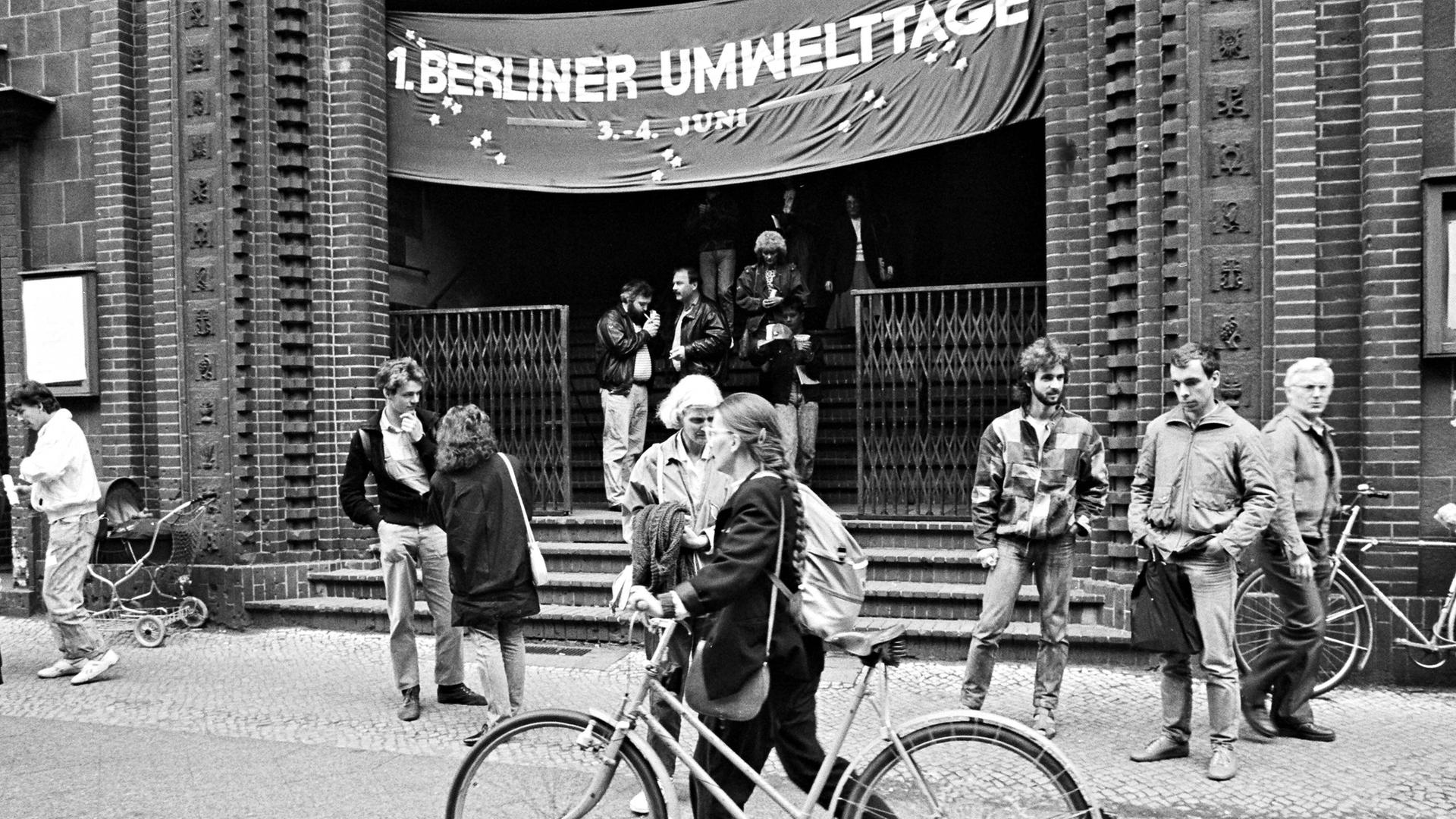 Vor einer Kirche stehen Menschen und unterhalten sich miteinander. Das Foto ist schwarzweiß, es stammt aus dem Jahr 1988 und wurde bei den 1. Berliner Umwelttagen in der Bekenntniskirche in Alt-Treptow in Ostberlin aufgenommen. Vor einer Kirche stehen Menschen und unterhalten sich miteinander. Das Foto ist schwarzweiß, es stammt aus dem Jahr 1988 und wurde bei den 1. Berliner Umwelttagen in der Bekenntniskirche in Alt-Treptow in Ostberlin aufgenommen.
