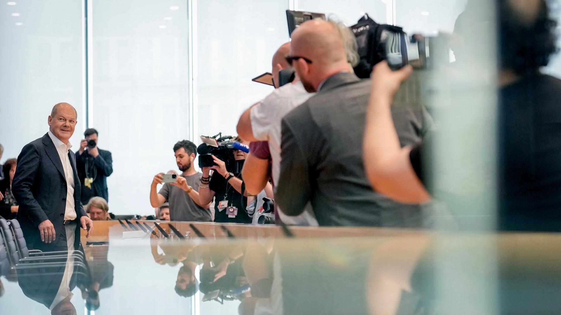 Bundeskanzler Scholz vor Beginn der Sommerpressekonferenz. Er ist von Fotografen umringt. Bundeskanzler Scholz vor Beginn der Sommerpressekonferenz. Er ist von Fotografen umringt.