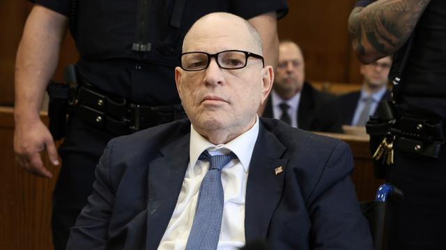 Ein älterer Mann mit Brille sitzt in einem Gerichtsaal und blickt ernst in die Kamera. Ein älterer Mann mit Brille sitzt in einem Gerichtsaal und blickt ernst in die Kamera.