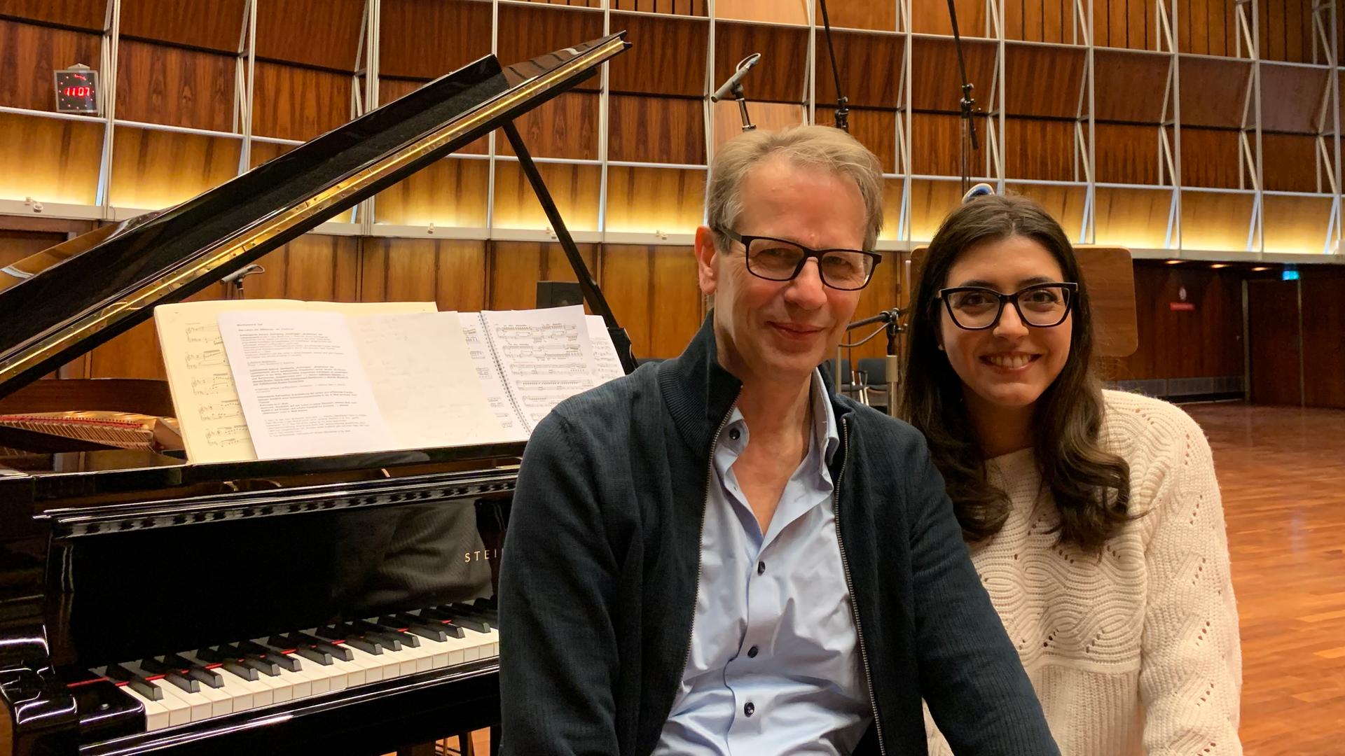 Christoph Schmitz sitzt neben Sophie Pacini auf einer Klavierbank vor dem aufgeklappten Flügel im Kammermusiksaal Köln.