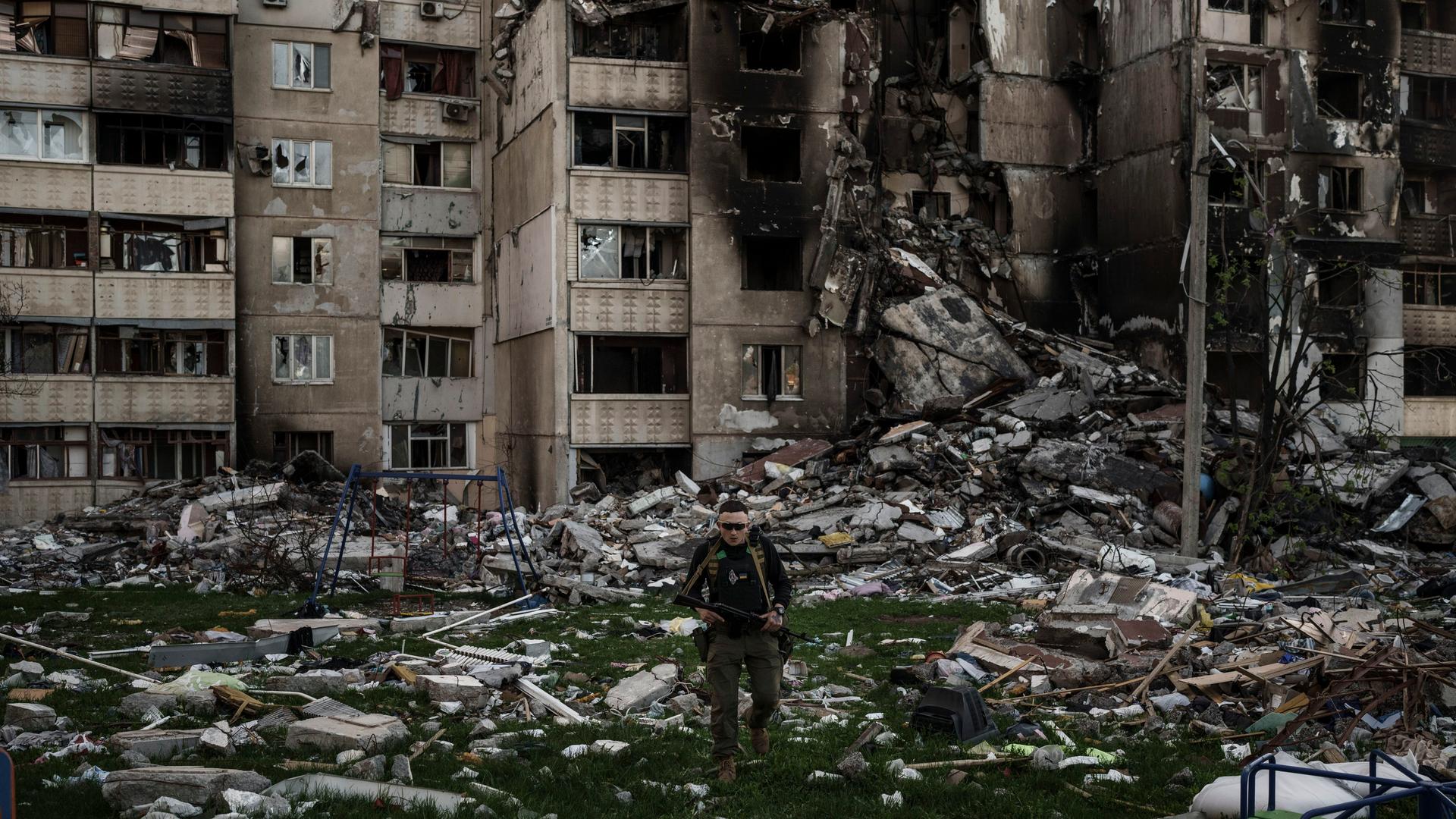 Ein ukrainischer Soldat steht inmitten von Kriegstrümmern im größtenteils zerstörten Charkiw.