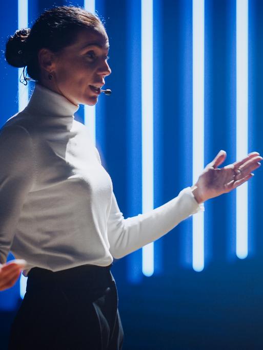 Eine Ted-Talkerin auf der Bühne Eine Ted-Talkerin auf der Bühne