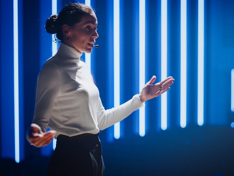 Eine Ted-Talkerin auf der Bühne Eine Ted-Talkerin auf der Bühne