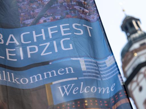 Ein Fahne des Bachfests Leipzig weht am Eröffnungstag neben dem Turm der Thomaskirche. 