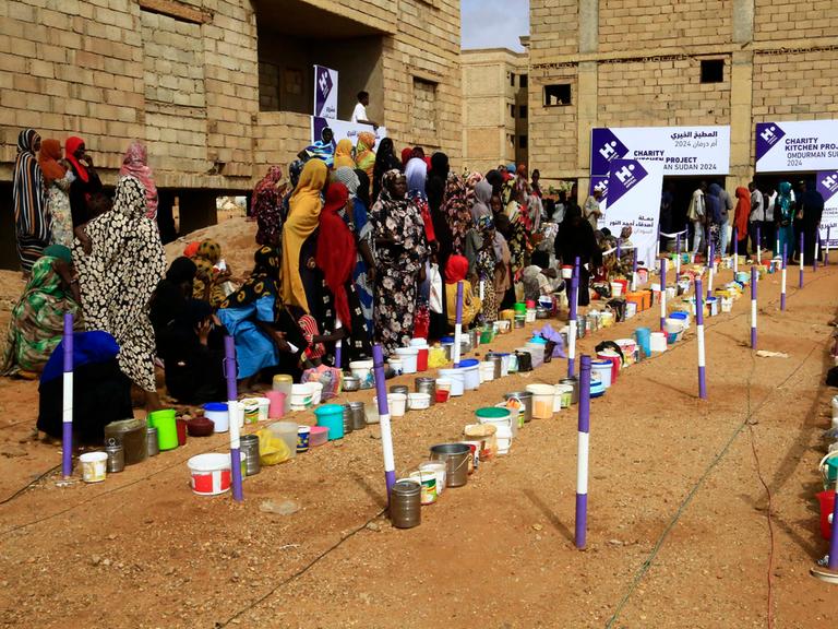 Vertriebene versammeln sich am 1. August 2024 in einem Viertel in der sudanesischen Stadt Omdurman, um ein kostenloses Frühstück zu erhalten. 