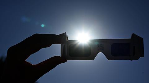 Eine Sonnenfinsternisbrille vor der Sonne
