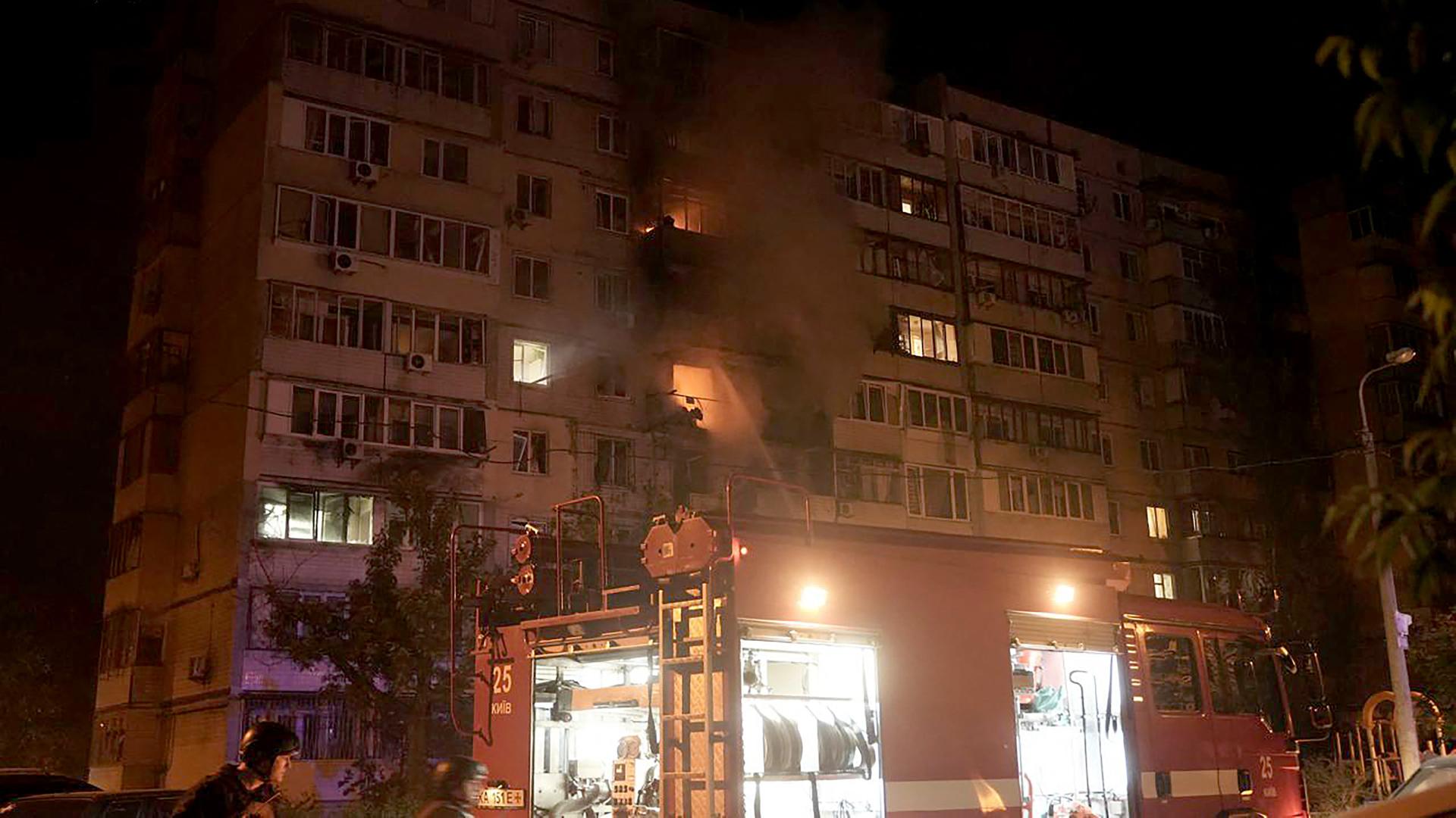Feuerwehrautos stehen vor einem Gebäude, in dem es brennt. Feuerwehrautos stehen vor einem Gebäude, in dem es brennt.