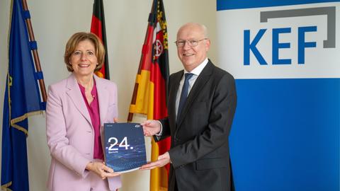 Der KEF-Vorsitzende Martin Detzel und Malu Dreyer (SPD), Ministerpräsidentin von Rheinland-Pfalz und Vorsitzende der Rundfunkkommission der Länder, halten gemeinsam den 24. KEF-Bericht in den Händen