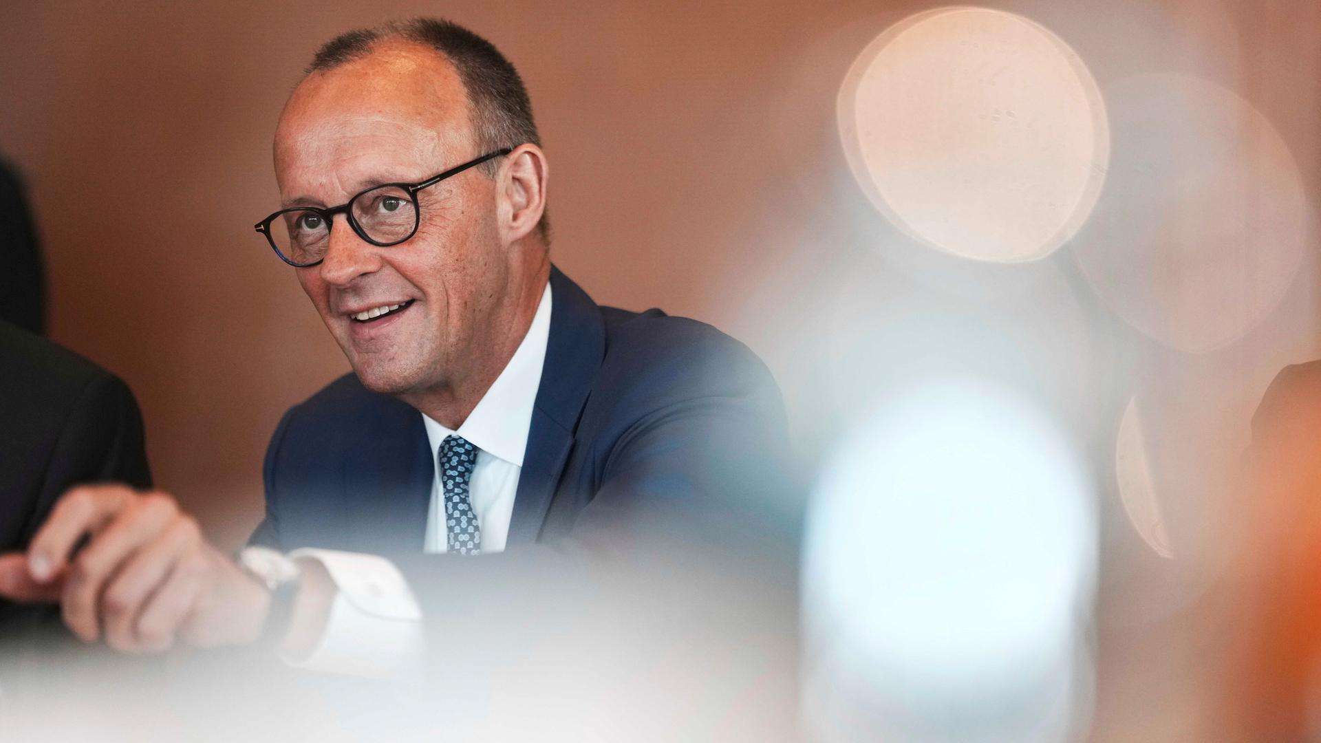 Portraitbild von Friedrich Merz mit verschwommenen Lichtpunkten
