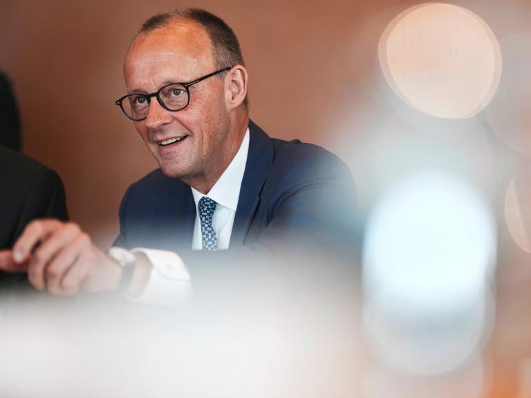 Portraitbild von Friedrich Merz mit verschwommenen Lichtpunkten
