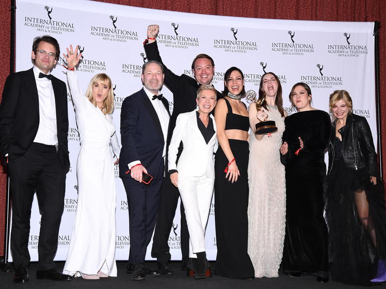 Das Team der deutschen Filmserie "Liebes Kind" mit Regisseurin Isabel Kleefeld (Mitte) feiert auf einer Bühne in New York den Gewinn den International Emmy. 