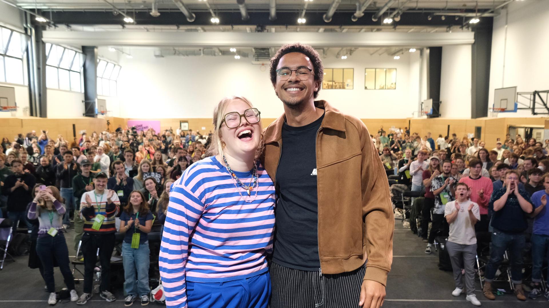 Henriette Held und Luis Bobga stehen nach ihrer Wahl beim Bundeskongress in Leipzig auf der Bühne. Sie freuen sich. 