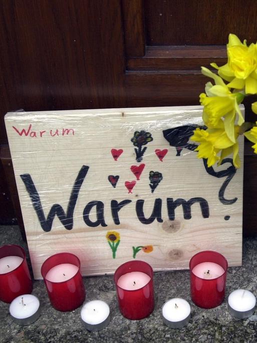 Blumen, Kerzen und ein Schild mit der Aufschrift "Warum?" stehen am 26.04.2002 in Erfurt an einem Eingang des Gutenberg-Gymnasiums in Erfurt. In einem entsetzlichen Amoklauf hatte ein ehemaliger Schüler in diesem Gymnasium 16 Menschen und sich selbst erschossen.