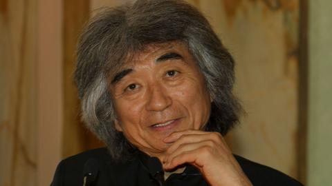 Portrait des Dirigenten Seiji Ozawa, der hier mit seinen typisch grau-wilden Haaren freundlich in die Kamera schaut. Foto aus dem Jahr 2002.