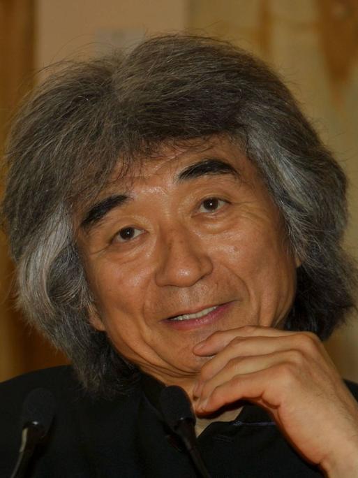 Portrait des Dirigenten Seiji Ozawa, der hier mit seinen typisch grau-wilden Haaren freundlich in die Kamera schaut. Foto aus dem Jahr 2002.