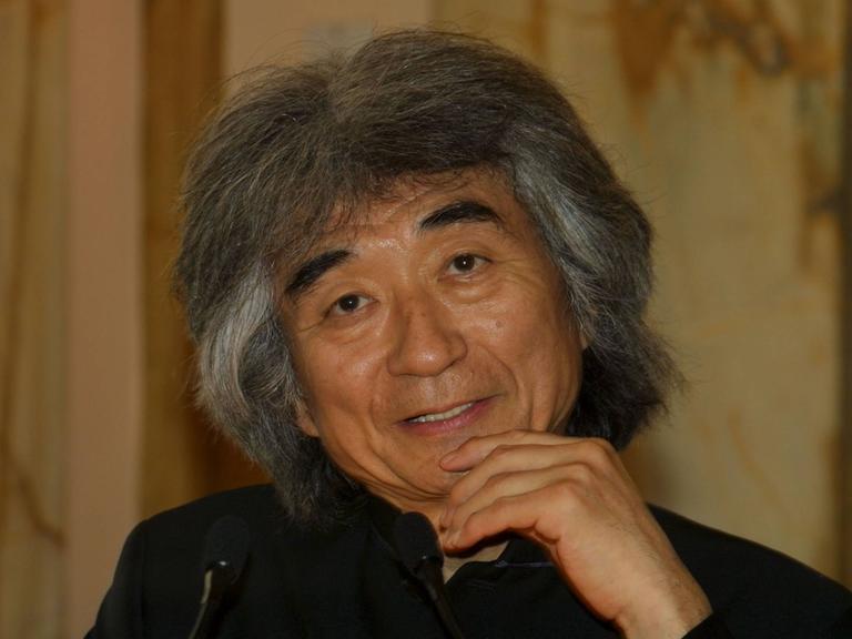 Portrait des Dirigenten Seiji Ozawa, der hier mit seinen typisch grau-wilden Haaren freundlich in die Kamera schaut. Foto aus dem Jahr 2002.