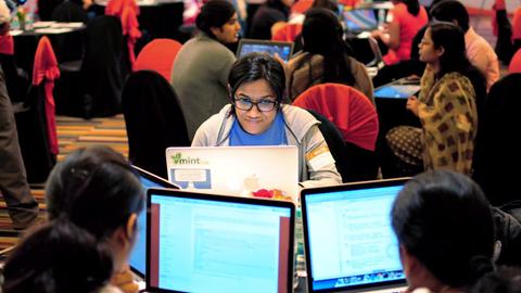 Mehrere Frauen sitzen an ihren Laptops während eines Hackathons in Bangalore. 