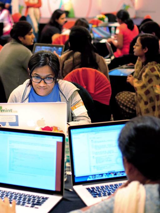 Mehrere Frauen sitzen an ihren Laptops während eines Hackathons in Bangalore. 