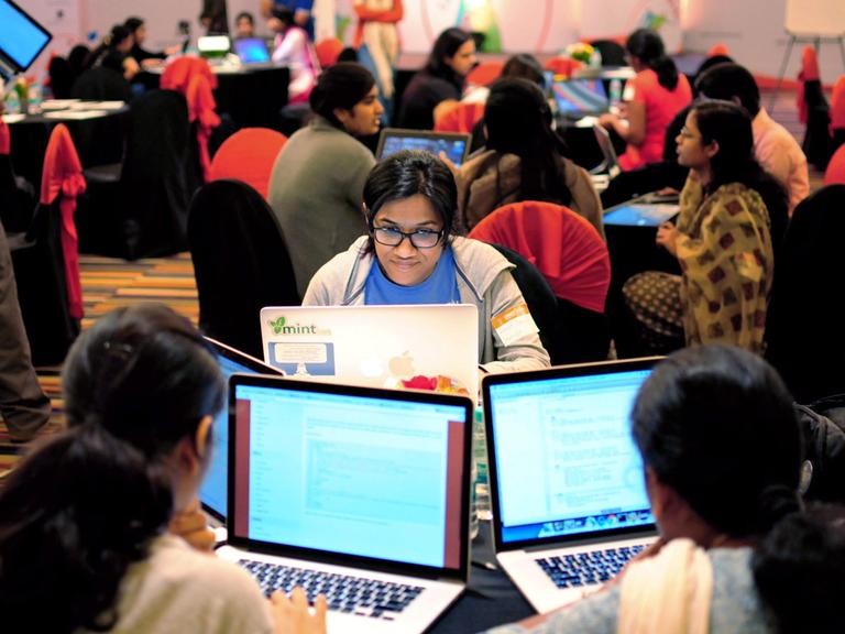 Mehrere Frauen sitzen an ihren Laptops während eines Hackathons in Bangalore. 