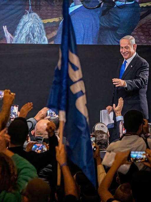 Benjamin Netanyahu auf einer Wahlbühne mit Unterstützern, die ihn fotografieren, November 2022.