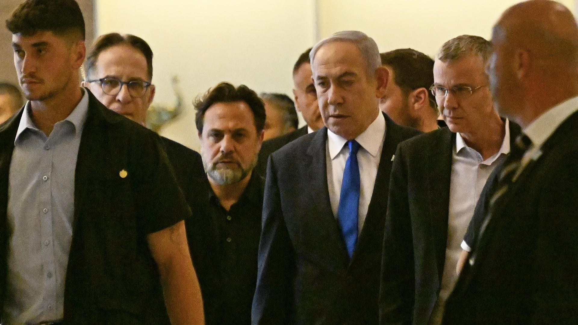 Israels Premierminister  Benjamin Netanyahu läuft mit weiteren Personen durch das israelische Parlamentsgebäude in Jerusalem.