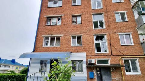 Zu sehen ist ein mehrstöckiges Wohnhaus. Einige Fenster sind zerstört.