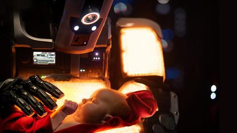 Filmstill aus: "I Am Mother" von Grant Sputore. Ein Roboter hält ein menschliches Baby in den Armen.
