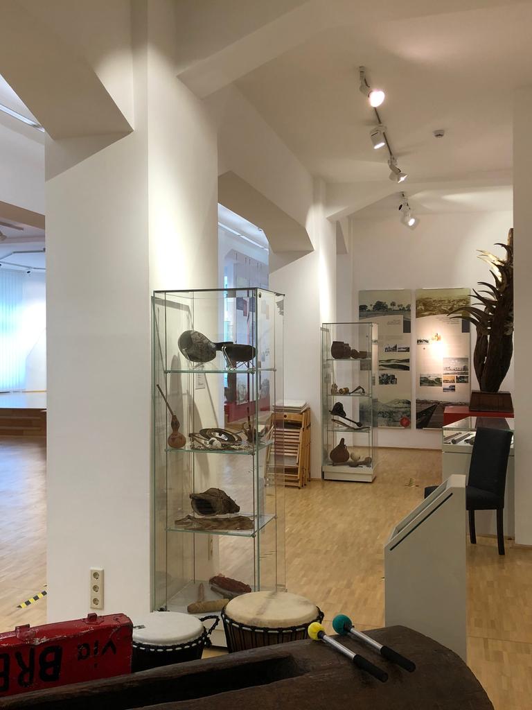 Museumraum mit zahlreichen Ausstellungsstücken aus Afrika, Asien und Ozeanien in Vitrinen und auf Sockeln.
