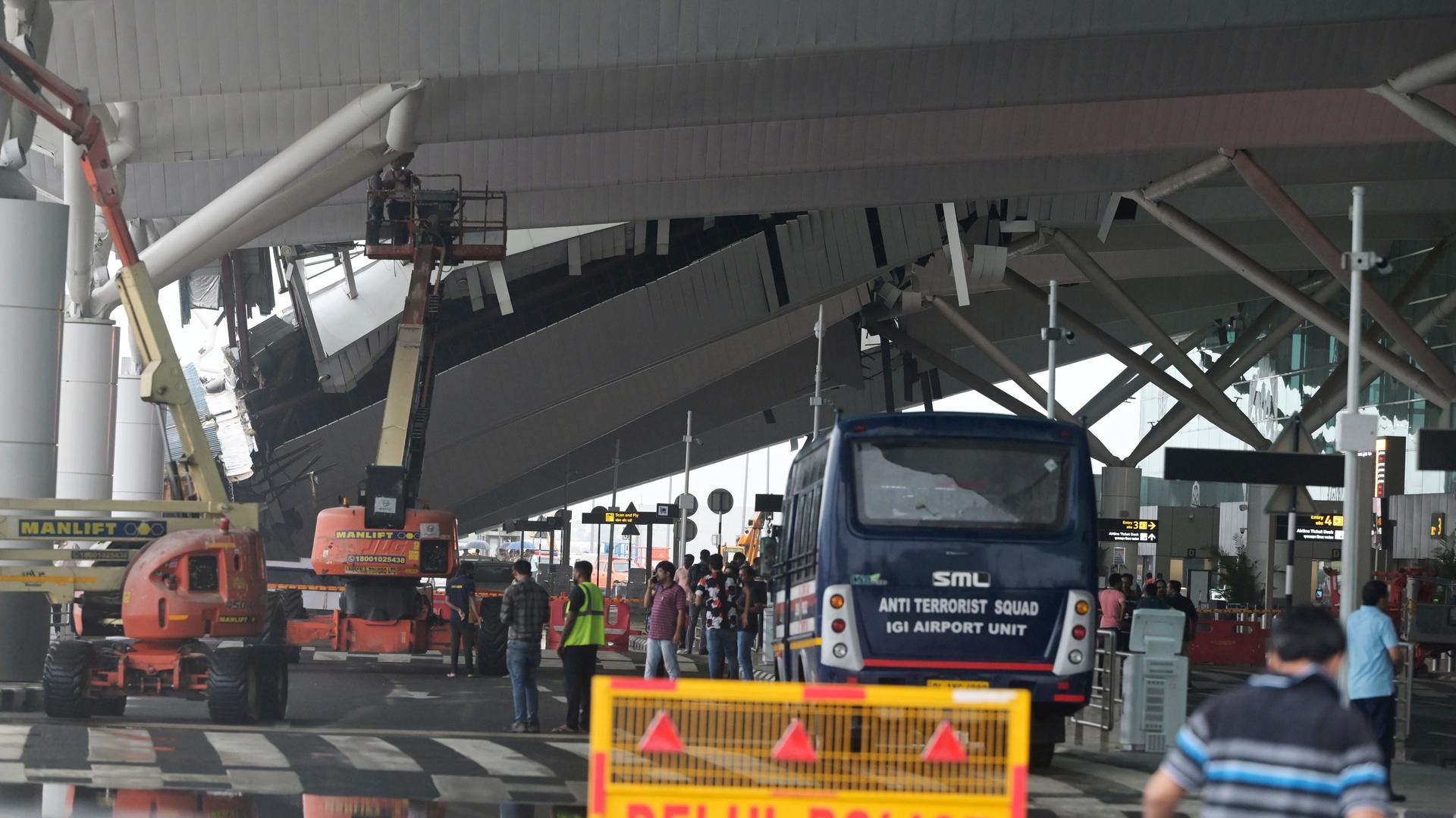 Am Flughafen von Neu Delhi ist das Dach eines Terminals eingestürzt - zu sehen sind mehrere Kräne und Menschen, die auf das Dach blicken. Am Flughafen von Neu Delhi ist das Dach eines Terminals eingestürzt - zu sehen sind mehrere Kräne und Menschen, die auf das Dach blicken.