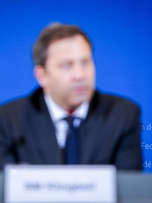 Lars Klingbeil sitzt bei einer Pressekonferenz. Die Aufnahme ist verschwommen, es ist nur die Silouette von Klingbeil zu erkennen. 