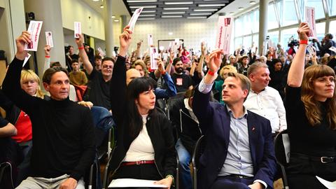 Der Landesparteitag der Berliner Linken: Ruben Lehnert (vorne, l-r), Schatzmeister, Elif Eralp, Fraktionsvorsitzende, Maximilian Schirmer, Partei-Vorsitzender, und Kerstin Wolter, Partei-Vorsitzende; sie halten Stimmzettel in die Höhe.
      