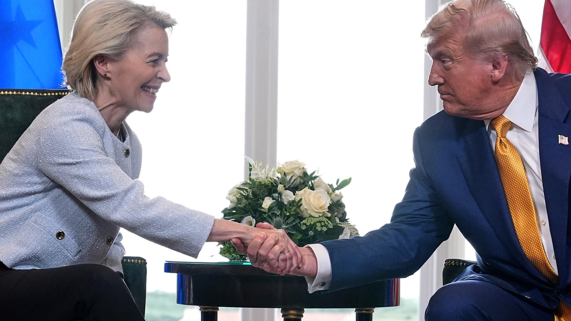 US-Präsident Trump traf die Präsidentin der Europäischen Kommission, von der Leyen, zu Gesprächen in Schottland. Beide schütteln die Hände und lächeln. US-Präsident Trump traf die Präsidentin der Europäischen Kommission, von der Leyen, zu Gesprächen in Schottland. Beide schütteln die Hände und lächeln.