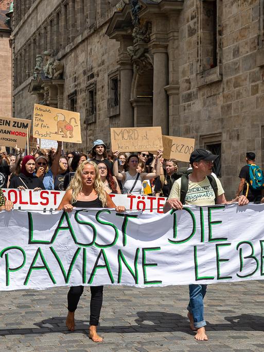 Demonstrationszug in der Innenstadt von Nürnberg gegen die geplante Tötung von Guinea-Pavianen im Tiergarten Nürnberg. An der Spitze der Versammlung tragen mehrere Personen ein grosses Transparent mit der Aufschrift "Lasst die Paviane leben!".