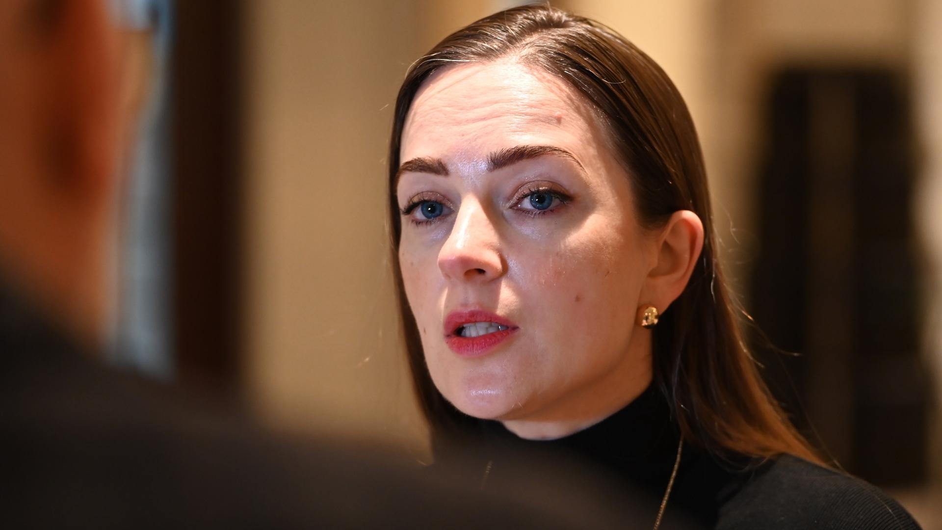 Oleksandra Matwijtschuk, eine Frau mit langem braunem Haar, blickt einen Gesprächspartner an, der mit dem Rücken zur Kamera steht. Sie spricht.