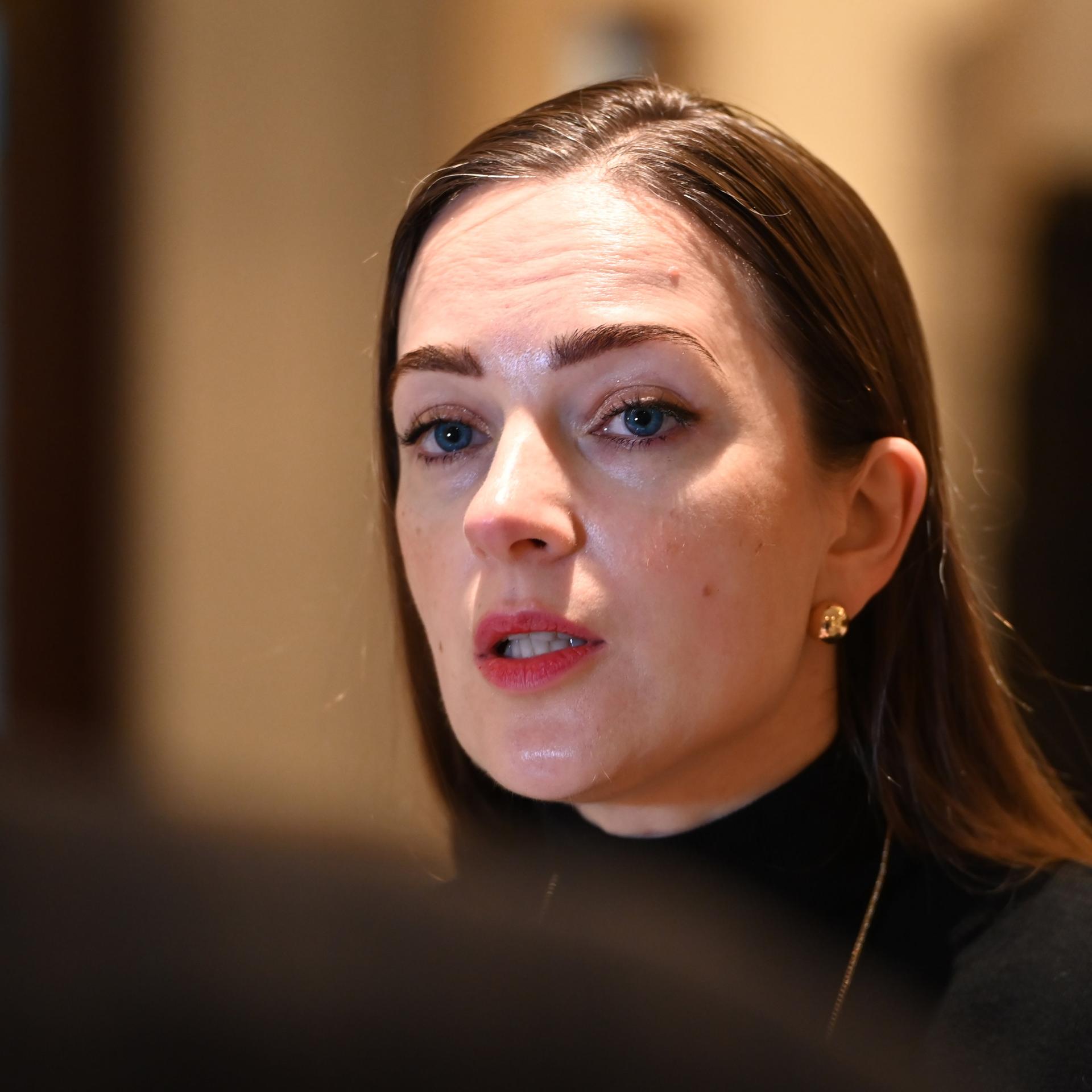 Oleksandra Matwijtschuk, eine Frau mit langem braunem Haar, blickt einen Gesprächspartner an, der mit dem Rücken zur Kamera steht. Sie spricht.