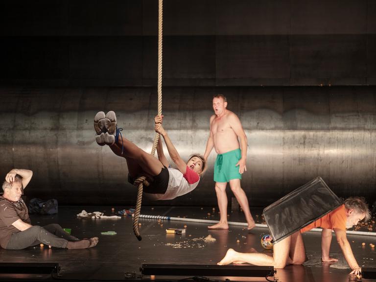 Die Schauspieler André Jung, Ursina Lardi, Devid Striesow und Sebastian Blomberg (v.li.) auf der Bühne in einer Szene des Stücks "Verrückt nach Trost".