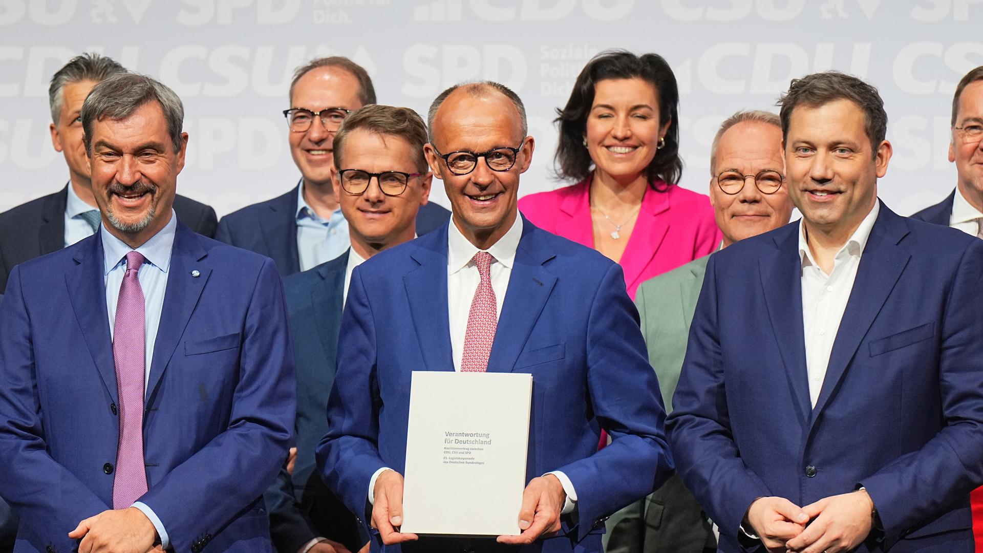 CDU-Vorsitzender und -Kanzlerkandidat Friedrich Merz (M), CSU-Vorsitzender Markus Söder (l) und SPD-Vorsitzender Lars Klingbeil (r) stehen nach der Unterzeichnung des Koalitionsvertrags auf der Bühne. CDU-Vorsitzender und -Kanzlerkandidat Friedrich Merz (M), CSU-Vorsitzender Markus Söder (l) und SPD-Vorsitzender Lars Klingbeil (r) stehen nach der Unterzeichnung des Koalitionsvertrags auf der Bühne.