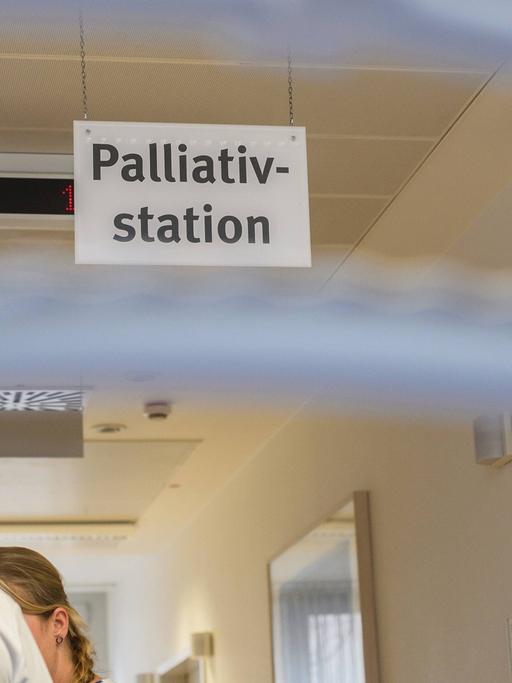 Ein Stationsarzt und eine Krankenschwester während einer Visite auf einer Palliativstation.