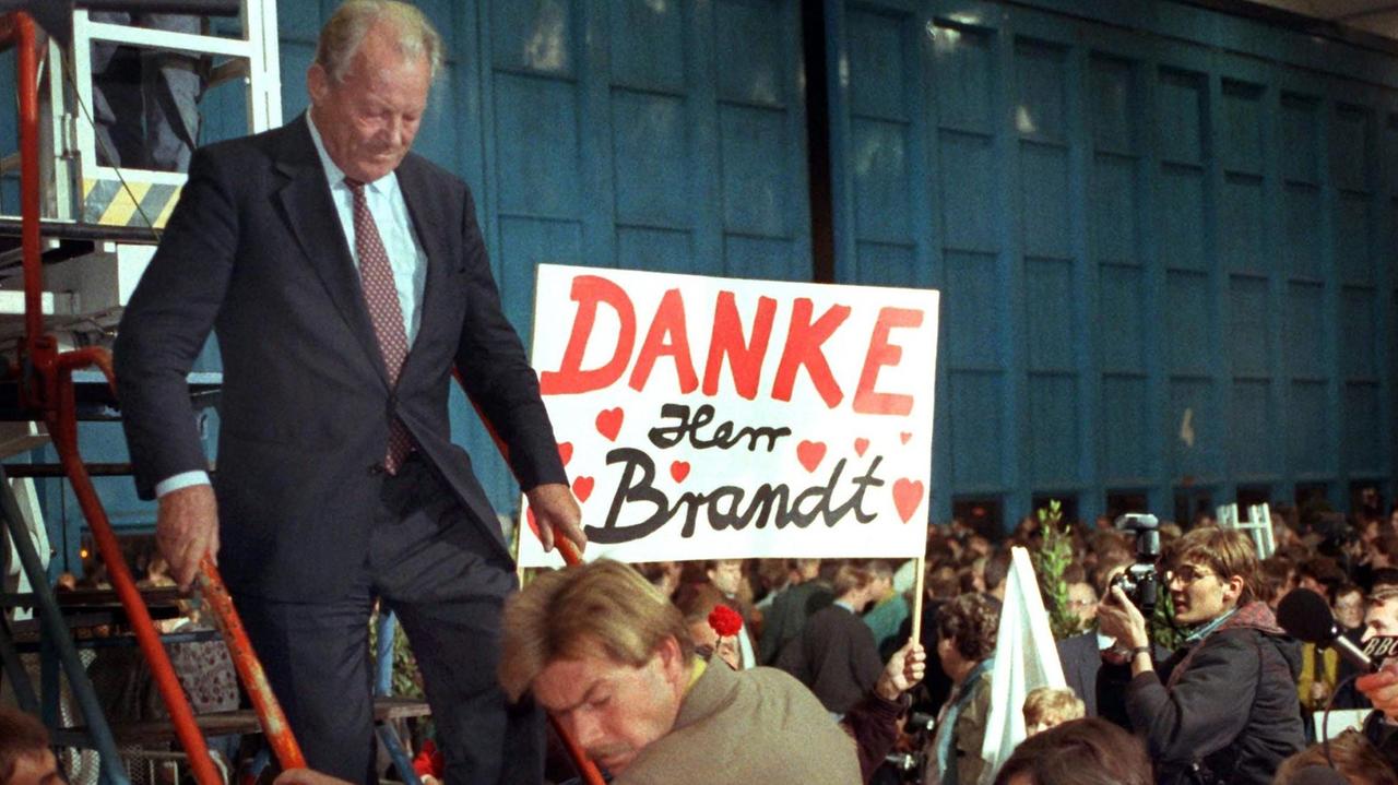 Mit einem Schild "Danke Herr Brandt" drücken Angehörige der Geiseln, die Willy Brandt (auf der Treppe) aus Irak nach Frankfurt gebracht hatte, ihre Dankbarkeit aus. 
