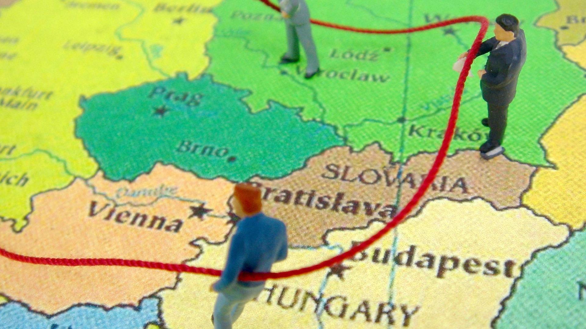 Eine Landkarte Europas, auf einer rote Linie die Wanderung von Arbeitern symbolisiert. Drei verteilte Figuren stellen Arbeiter da.