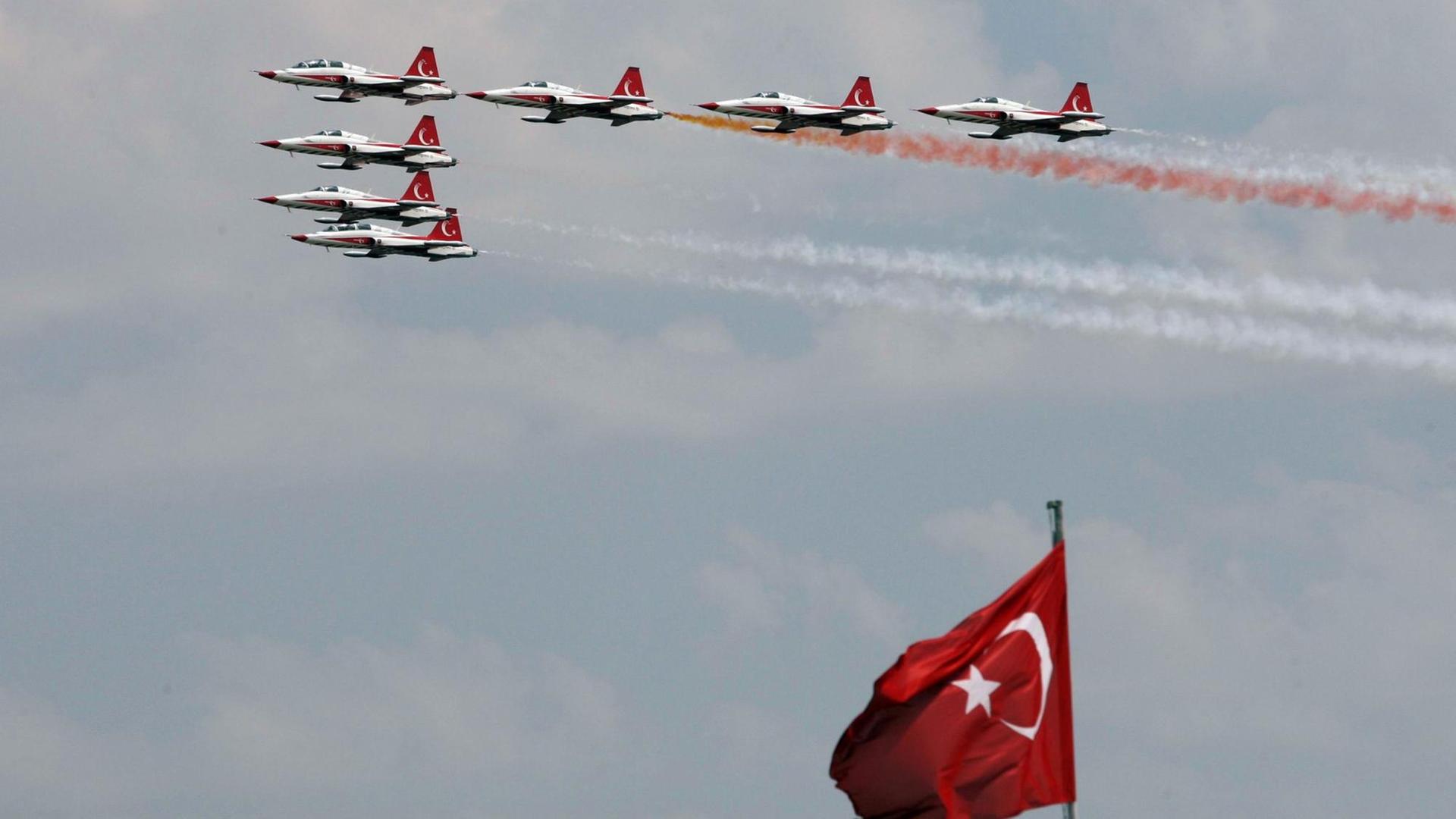 Türkische Kampfjets fliegen bei einer Parade eine Formation.