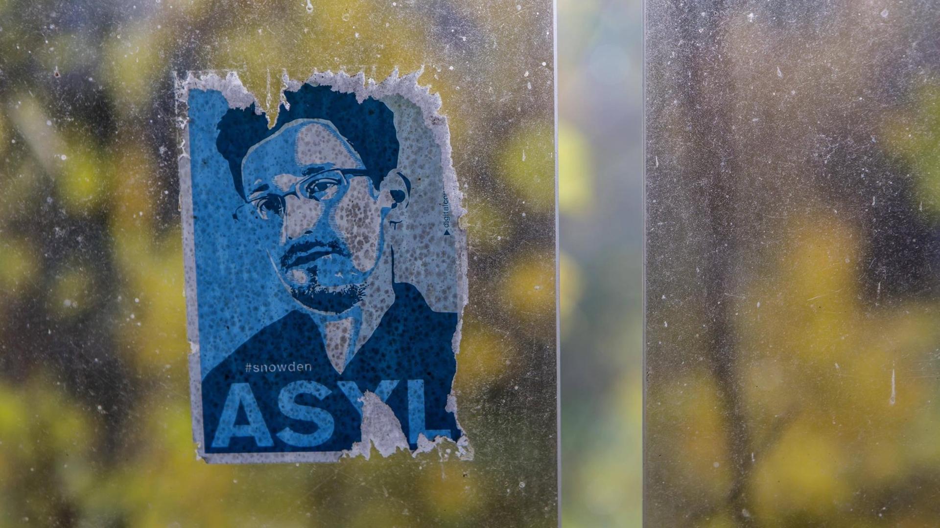 Ein Aufkleber mit dem Portrait von Edward Snowden an einer Bushaltestelle.