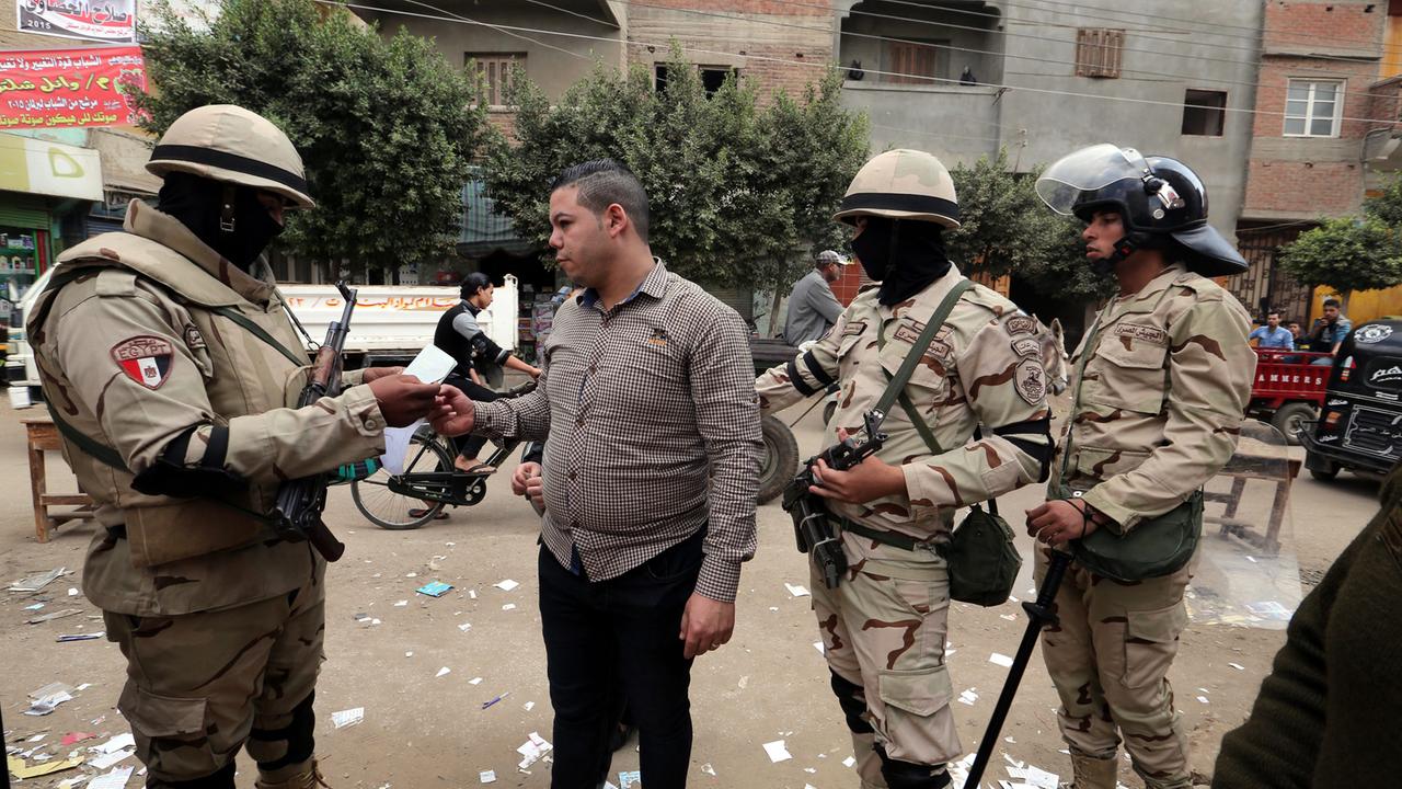 Ägyptische Soldaten kontrollieren den Ausweis eines Wählers am zweiten Tag der finalen Wahlrunde zur Parlamentswahl, aufgenommen in Tanta am 23. November 2015.