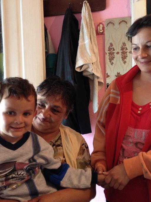 Neli Moc mit ihrer Tochter und Enkelkind Sebi in der Küche ihres kleinen Hauses im rumänischen Dorf Apoldu de Sus.