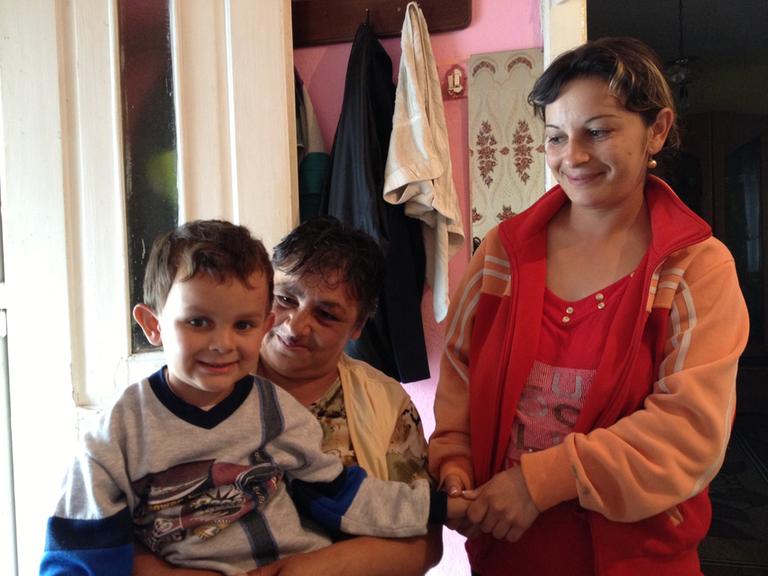 Neli Moc mit ihrer Tochter und Enkelkind Sebi in der Küche ihres kleinen Hauses im rumänischen Dorf Apoldu de Sus.