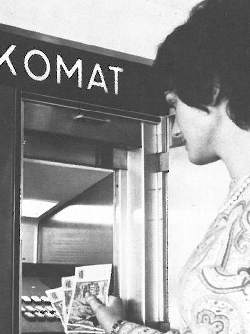 Eine Bank-Kundin hebt 1971 an einem "Bankomat" Bargeld ab