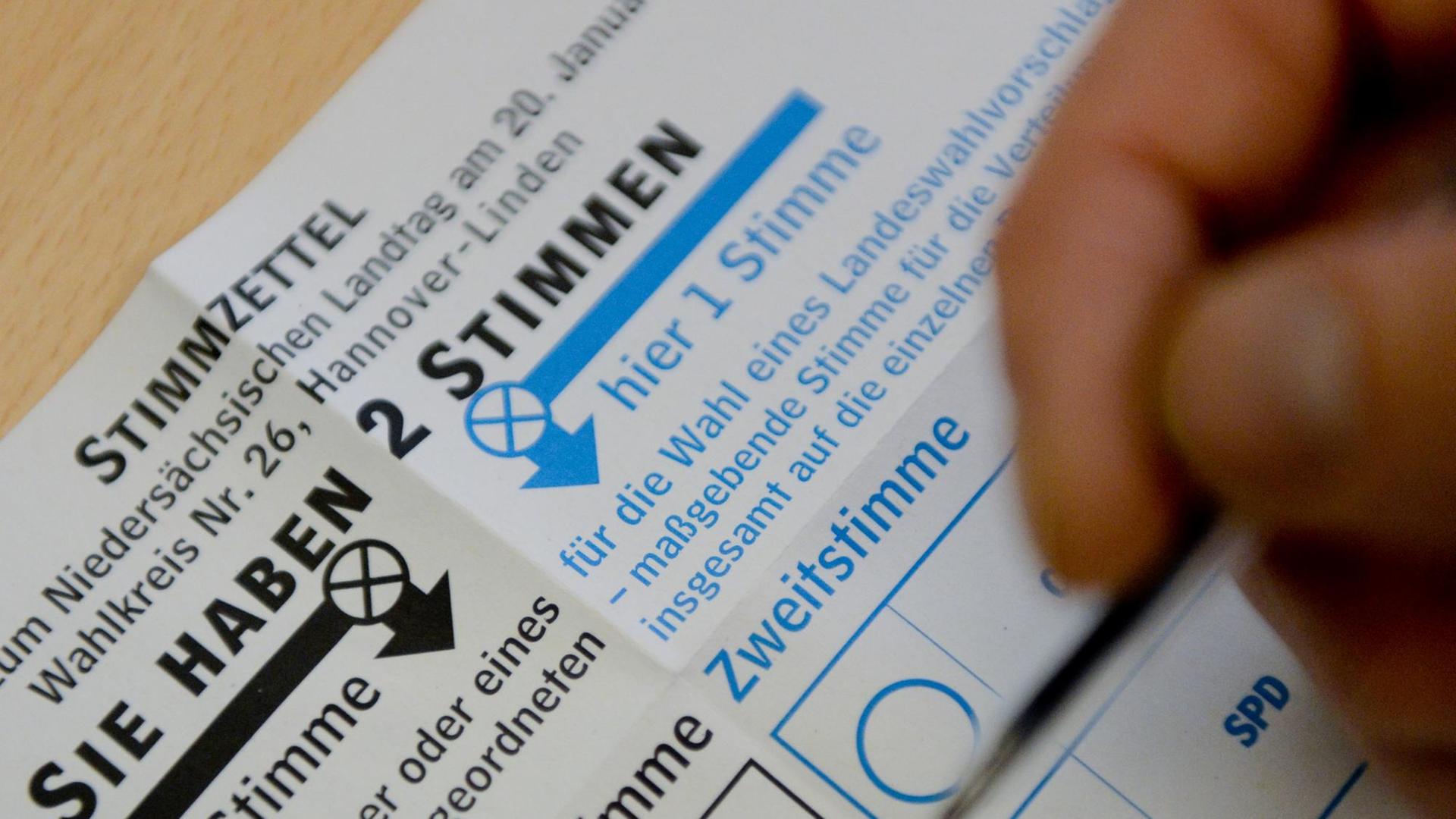 Ein Wähler macht in Hannover auf seinem Stimmzettel die Kreuze.